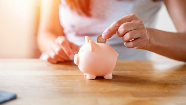 Article thumbnail: Woman putting coins to piggi bank.