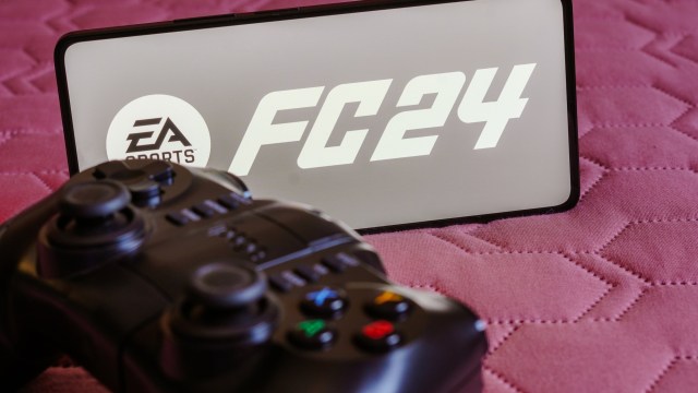 Article thumbnail: BRAZIL - 2023/10/09: In this photo illustration, the EA SPORTS FC 24 logo is displayed on a smartphone screen, next to a gamepad. (Photo Illustration by Rafael Henrique/SOPA Images/LightRocket via Getty Images)