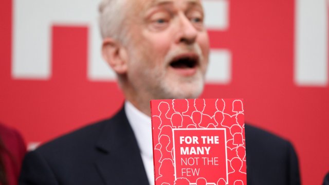 Article thumbnail: Jeremy Corbyn, leader of the U.K. opposition Labour Party, holds a copy of the party's manifesto at a speech marking its publication in Bradford, U.K., on Tuesday, May 16, 2017. Corbyn will seek to rally support behind an agenda of increased taxes for the wealthy and more spending on public services. Photographer: Chris Ratcliffe/Bloomberg via Getty Images