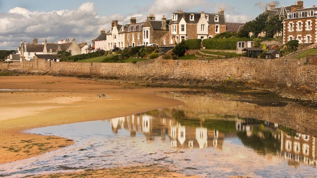 Article thumbnail: Traditional Scottish houses line the shore and are reflected in a tidal pool left on the beach at Elie,a typical village in the east neuk of Fife in Scotland