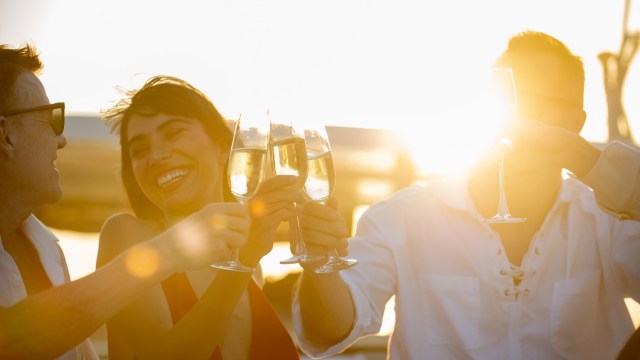 Article thumbnail: Blurred Group of People man and woman friends enjoy party drinking champagne together while catamaran boat sailing at summer sunset. Male and female relax outdoor lifestyle activity on travel vacation