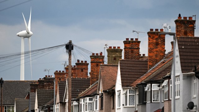 Article thumbnail: A wind turbine turns behind terraced houses in Dagenham, east London, on July 13, 2024. New UK finance minister Rachel Reeves has vowed to immediately "fix the foundations" of Britain's economy, fuelled by onshore wind power and house building, after her Labour party won power. (Photo by JUSTIN TALLIS / AFP) (Photo by JUSTIN TALLIS/AFP via Getty Images)